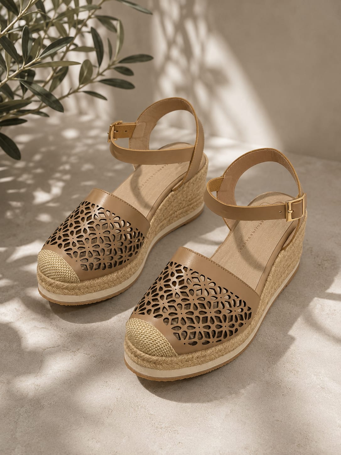 Sandalias de plataforma tipo espadrille en color taupe con diseño frontal calado, correa ajustable con hebilla al tobillo y suela cubierta de yute.